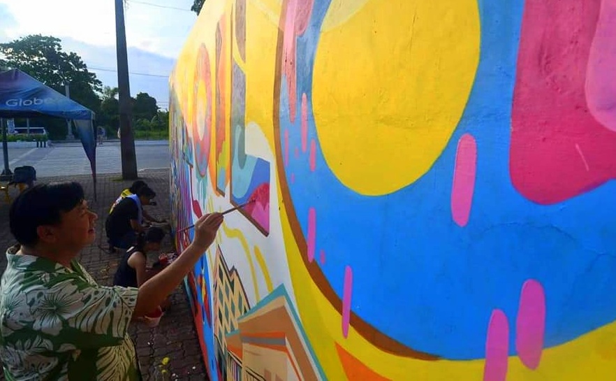 Mayor Jerry P. Treñas tried his hand at painting public art on the wall along bike lane in Brgy. Sambag in Jaro district Sunday.