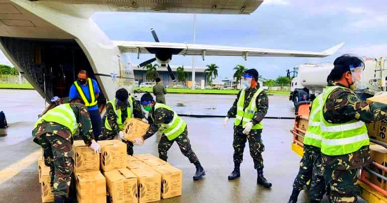 Philippine Airforce officers and other personnel help in unloading of food packs.