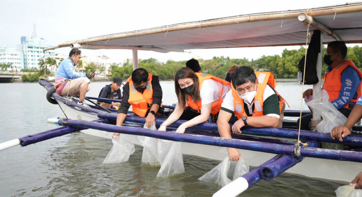 MORE Power executives releases fishes in Iloilo River.