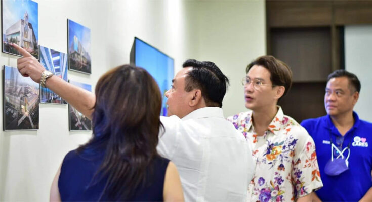 Mayor Jerry Trenas checks the proposed designs of Central and Super markets.