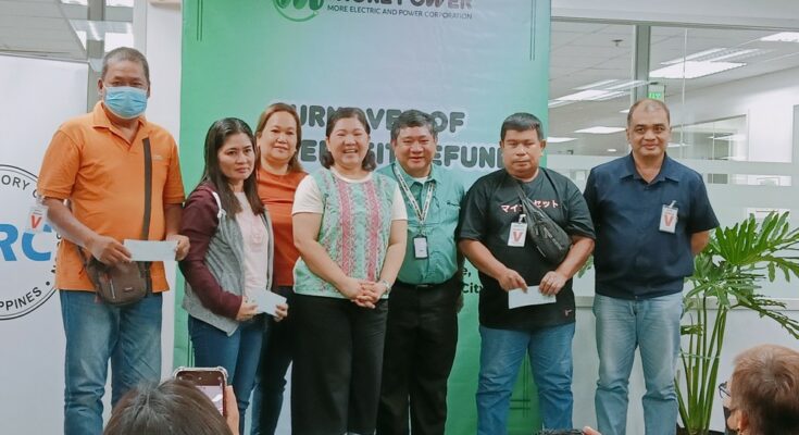 ERC chair Monalisa Dimalanta with consumers who get their Bill Deposit Refund